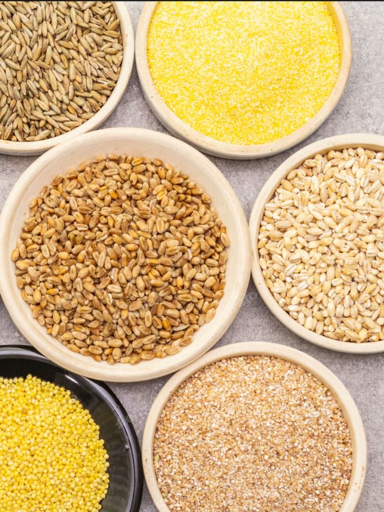 Bowls of wheat, barley, millet, corn and broken grains laid out together